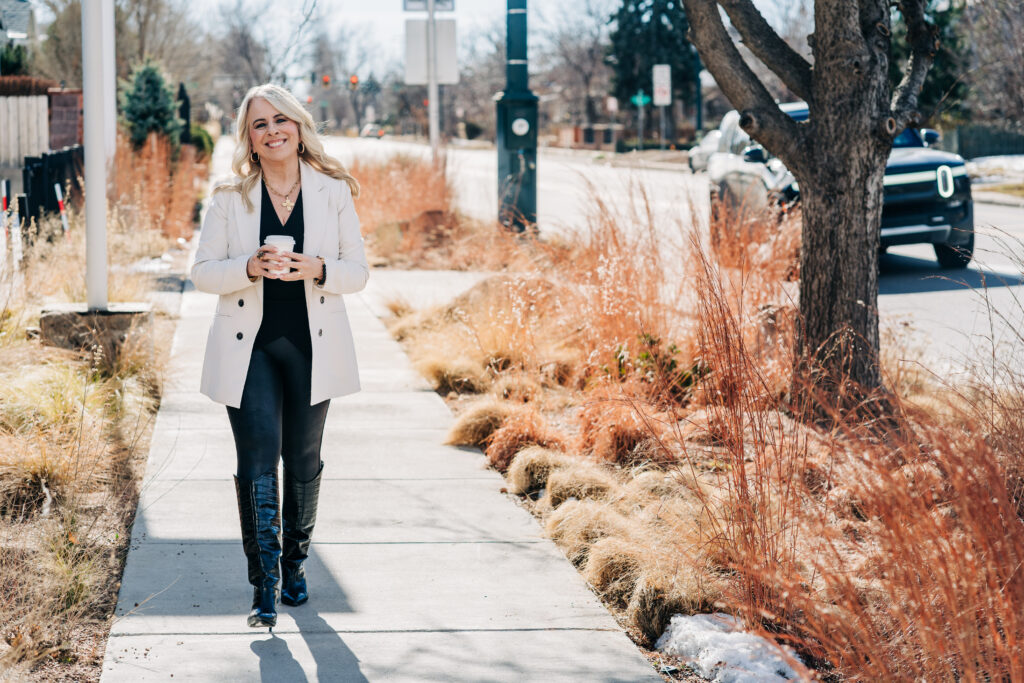 Jo Leda Martin Lakewood Colorado Counselor walking on sidewalk with coffee smiling